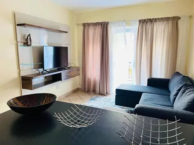 a living room with a blue couch and a tv at Karabo Spaces in Midrand