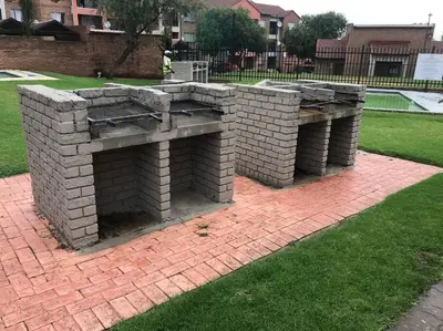 a brick fireplace on a brick sidewalk in a yard at Karabo Spaces in Midrand