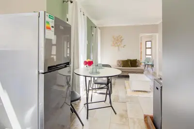 a kitchen with a table and a refrigerator at Kirrin Cottage in Benoni in Benoni