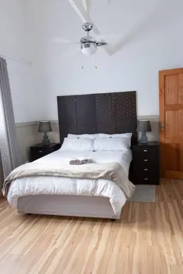 a bedroom with a large bed and two night stands at Lala Lapa Self Catering Accomodation in Nelspruit