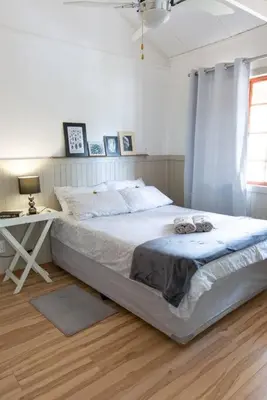a white bedroom with a bed and a desk at Lala Lapa Self Catering Accomodation in Nelspruit