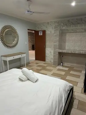 a bedroom with a large white bed and a bathroom at Eagles View Kungwini in Erasmus