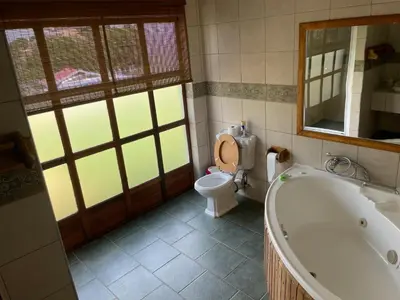 a bathroom with a tub and a toilet and a mirror at Eagles View Kungwini in Erasmus