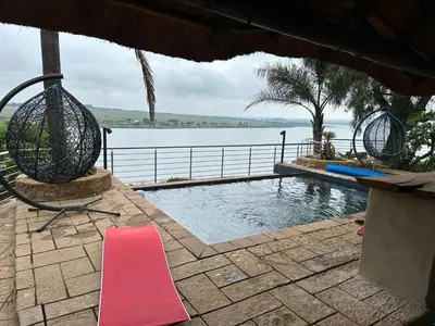 a swimming pool with a red mat next to the water at Eagles View Kungwini in Erasmus
