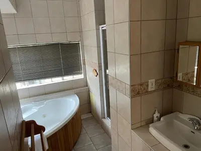 a bathroom with a tub and a sink at Eagles View Kungwini in Erasmus