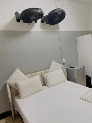 a bedroom with a bed with two speakers on the wall at Sunrise Guest Inn in Pretoria