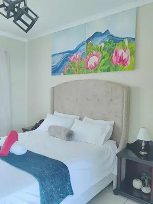 a bedroom with a white bed with a painting on the wall at Choosers Express Boutique Hotel and Spa - Room 2 in Centurion