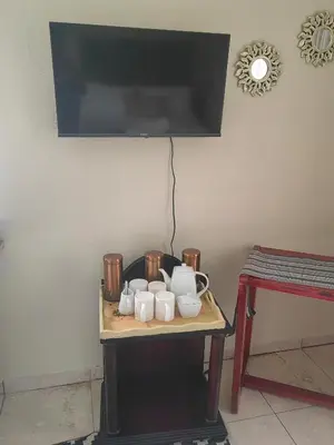 a table with mugs and a tv on a wall at Choosers Express Boutique Hotel and Spa - Room 2 in Centurion