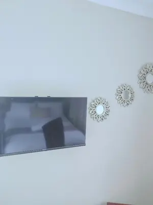 three clocks hanging on a white wall with a tv at Choosers Express Boutique Hotel and Spa - Room 2 in Centurion