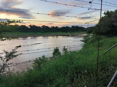 a view of a river with a barbed wire fence at Woodlands on Korhaan 2926 in Marloth Park