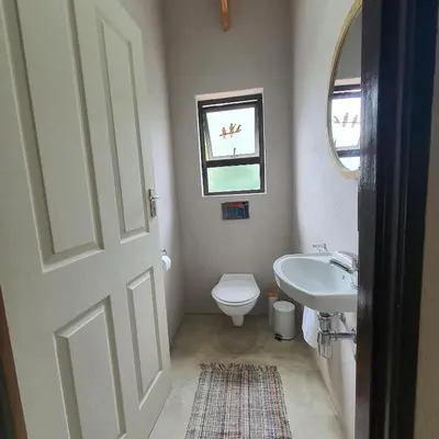 a bathroom with a toilet and a sink and a window at The Bird House in Kampersrus AH