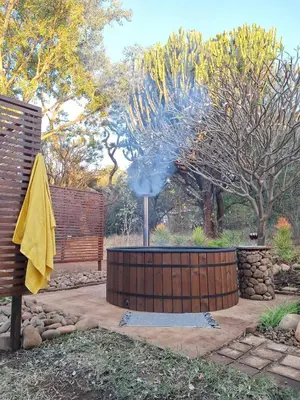 a fire pit in a garden with a yellow umbrella at The Bird House in Kampersrus AH