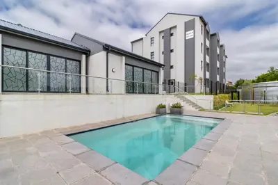 a swimming pool in front of a house at The Ace apartment @50 on lever(with backup power) in Midrand