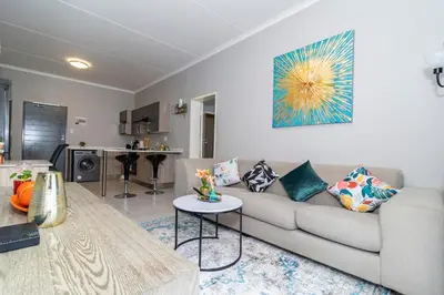 a living room with a couch and a table at The Ace apartment @50 on lever(with backup power) in Midrand