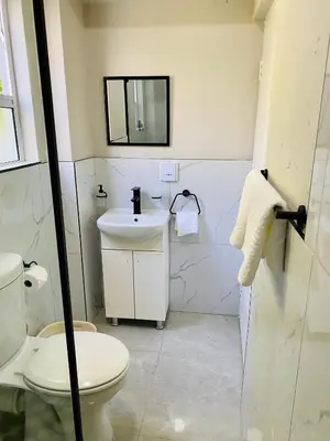 a bathroom with a toilet and a sink at Cozy Garden Facing Guest Suite -(Back up power) in Midrand