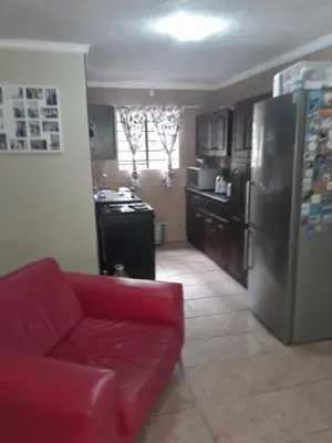 a kitchen with a red couch and a refrigerator at Kruger Bush Retreat in Marloth Park