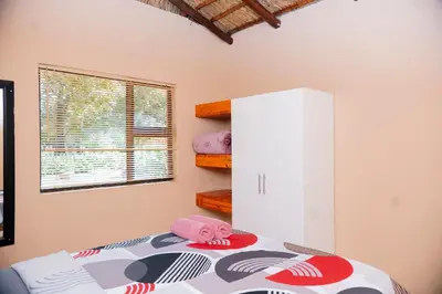 a bedroom with a bed with a pink stuffed animal on it at Falcon Lodge (ET) in Bela-Bela