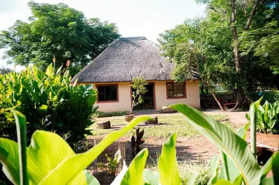 a small house with a thatched roof at Falcon Lodge (ET) in Bela-Bela