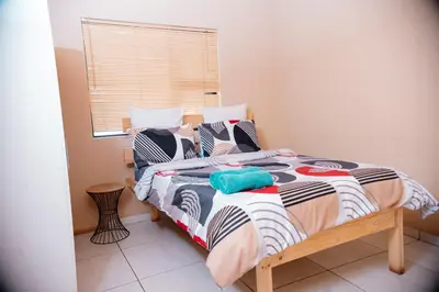a bedroom with a bed and a window at Falcon Lodge (ET) in Bela-Bela