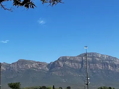 a mountain in the distance with a light pole in the foreground at @The Drakens Lodge in Hoedspruit
