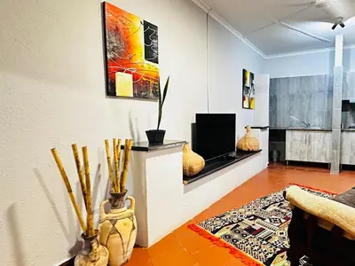 a living room with a couch and a television at @The Drakens Lodge in Hoedspruit
