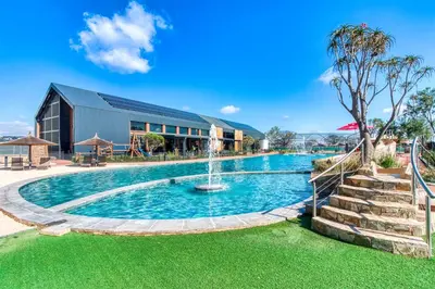 a pool with a fountain in front of a building at The Green Lifestyle Apartments in Pretoria