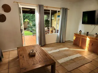 a living room with a coffee table and a sliding glass door at Selah, self-catering in Pretoria