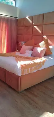 a bedroom with a large bed with a red headboard at Mulala Luxury Guesthouse in Thohoyandou