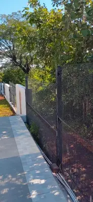 a fence next to a sidewalk next to a tree at Mulala Luxury Guesthouse in Thohoyandou