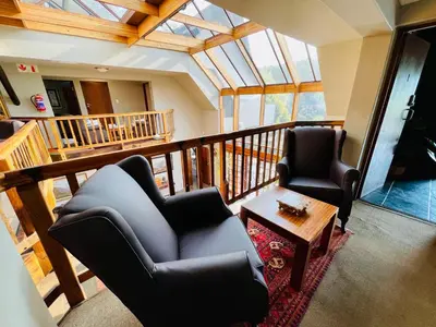 a living room with two chairs and a coffee table at Pretoria Mansion Boutique Hotel Coral Tree in Pretoria