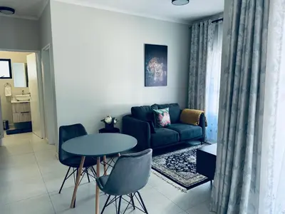 a living room with a couch and a table at Liams blue suite at 93 On New in Midrand
