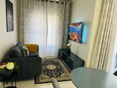 a living room with a couch and a table at Liams blue suite at 93 On New in Midrand
