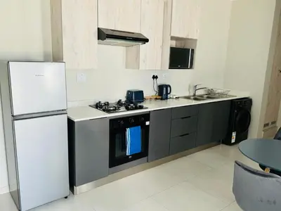 a kitchen with a stove and a refrigerator at Liams blue suite at 93 On New in Midrand