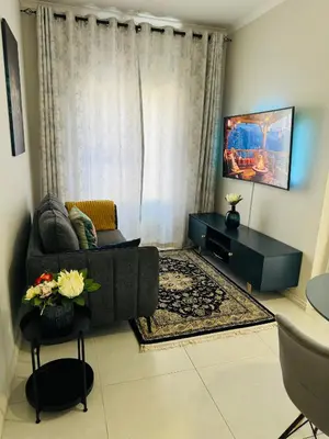 a living room with a couch and a window at Liams blue suite at 93 On New in Midrand