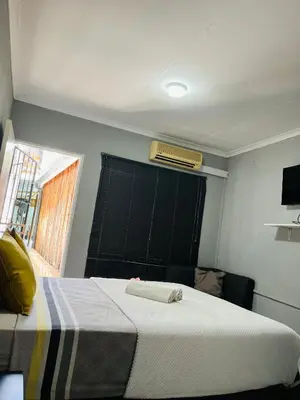 a bedroom with a bed and a window with a air conditioner at Ashridge Guesthouse & Safaris in Hazyview