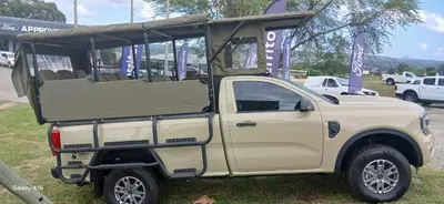 a tan pick up truck parked in a field at Ashridge Guesthouse & Safaris in Hazyview