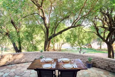 a wooden table with chairs and plates on it at Parsons River Camp in Balule Game Reserve