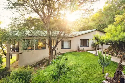 a white house with a tree in the yard at Parsons River Camp in Balule Game Reserve