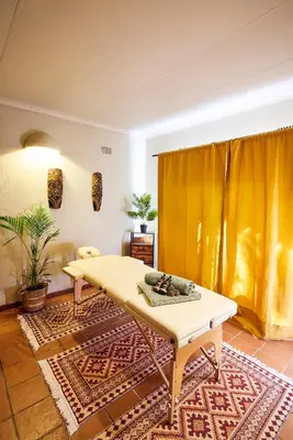 a living room with a yellow table and a rug at Parsons River Camp in Balule Game Reserve