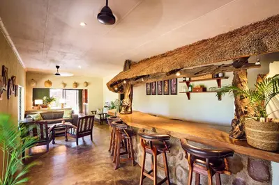 a bar in a restaurant with wooden tables and chairs at Parsons River Camp in Balule Game Reserve