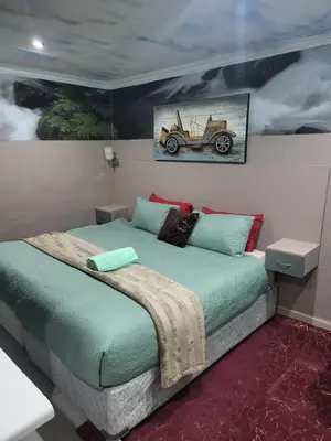 a bedroom with a bed with a car on the wall at Tshedza Guest House in Pretoria