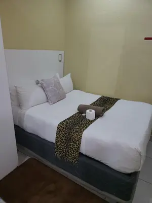 two beds sitting next to each other in a room at Tshedza Guest House in Pretoria