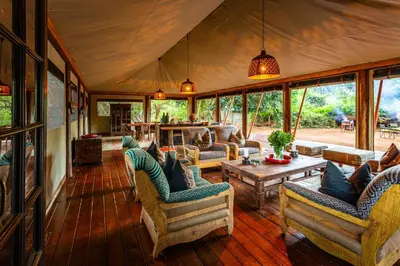 a living room with couches and a table at Hutwini Walking Camp by RETURN Africa in Makuleke Contract Park