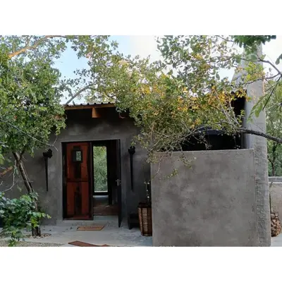 a small house with a door and a tree at The Nest - Marloth Park in Marloth Park