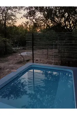 a swimming pool in front of a fence at The Nest - Marloth Park in Marloth Park