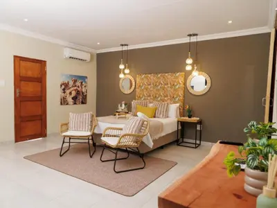 a bedroom with a bed and a table and chairs at Lions View Accommodation in Nelspruit