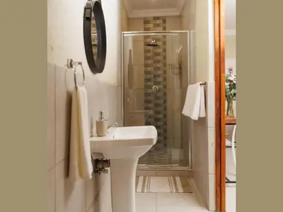 a white bathroom with a sink and a shower at Lions View Accommodation in Nelspruit