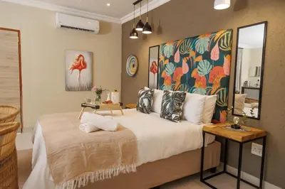 a bedroom with a large bed with a painting on the wall at Lions View Accommodation in Nelspruit