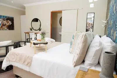 a bedroom with a white bed and a table at Lions View Accommodation in Nelspruit