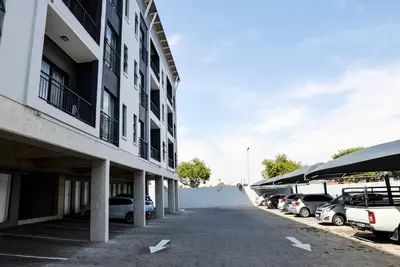 a parking lot with cars parked next to a building at Cozy Hidden gem in Midrand in Midrand